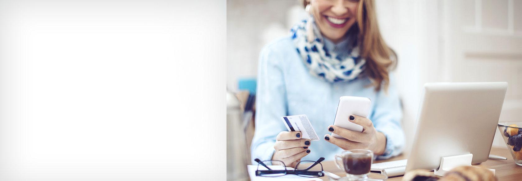 Woman using a debit card for a mobile transation. Smiling and happy.